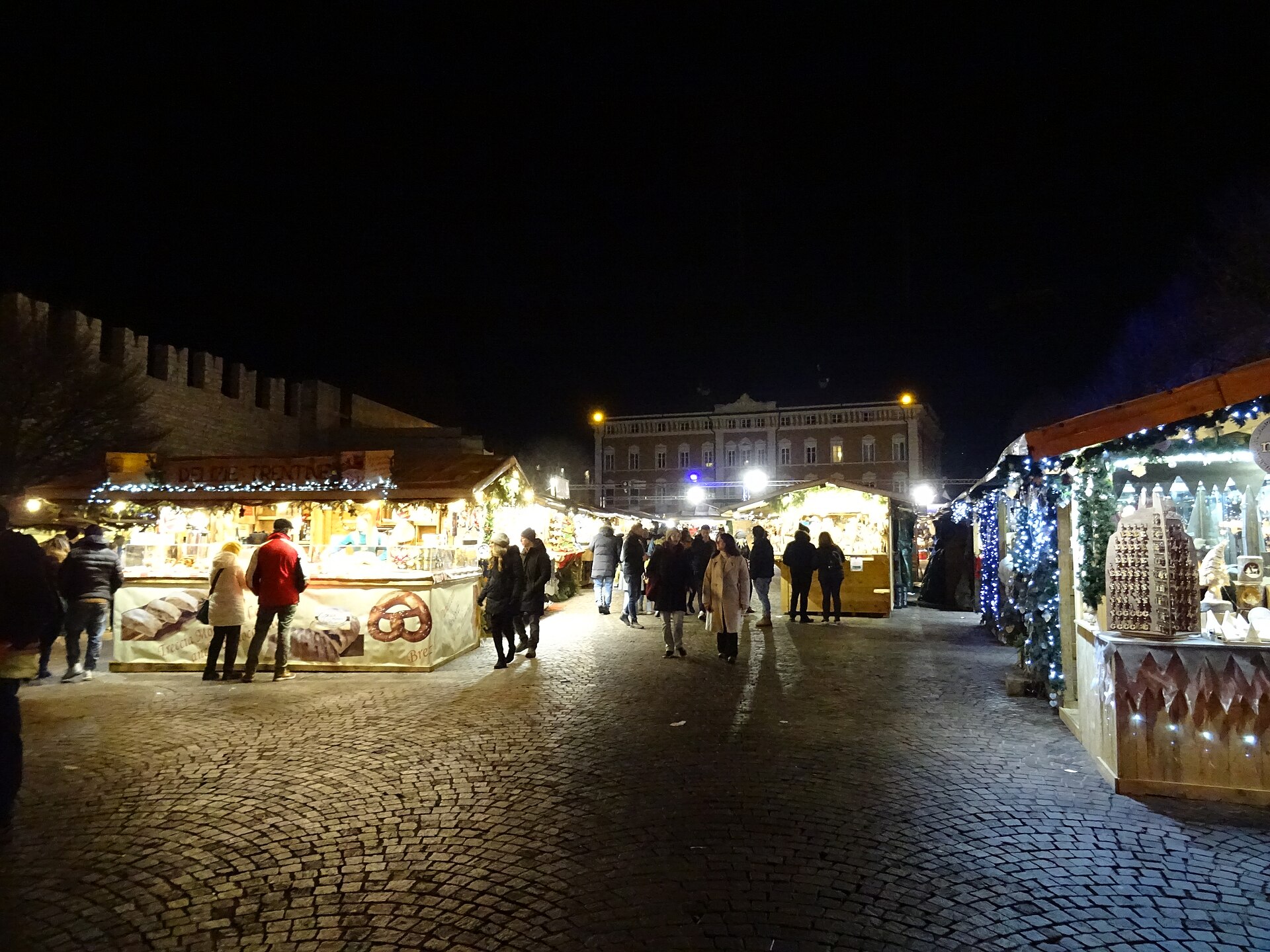 The Christmas market in Piazza Fiera, Trento, beneath the medieval walls