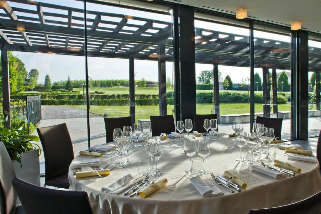 Tavola apparecchiata nella sala ristorante con vetrate sul parco dell'Albergo dell'Agenzia a Pollenzo