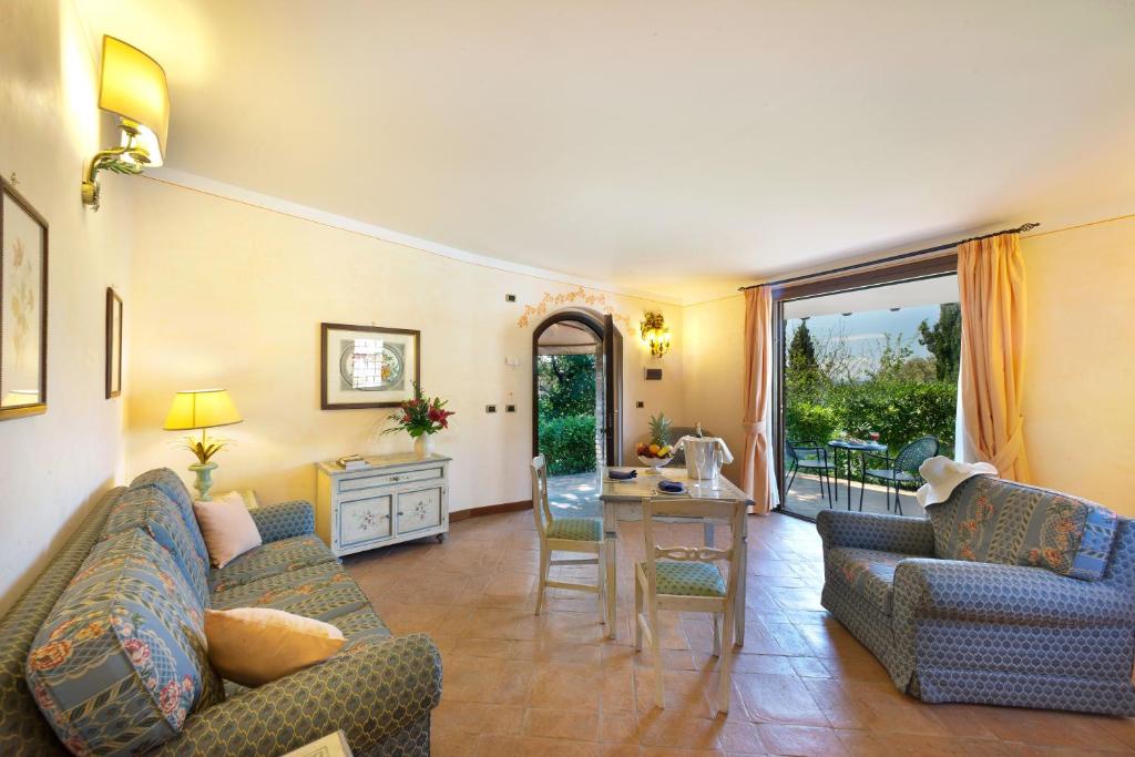 Soggiorno luminoso di una country suite del Relais il Canalicchio, con tavolo e affaccio sul verde