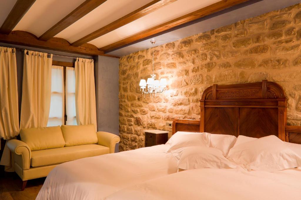 Habitación con muro de piedra y vigas de madera en la Hospedería de los Parajes, Laguardia