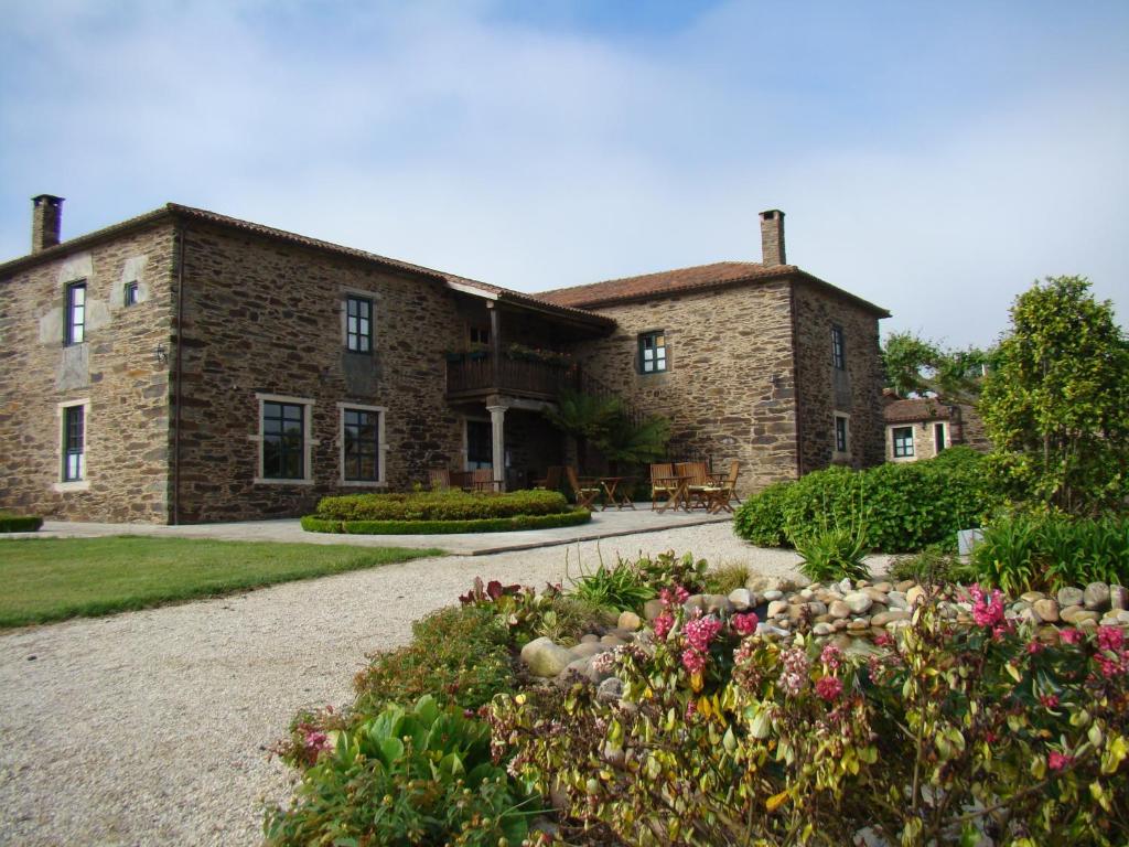 Fachada de piedra del Pazo Santa María en Arzúa, Galicia, con jardín