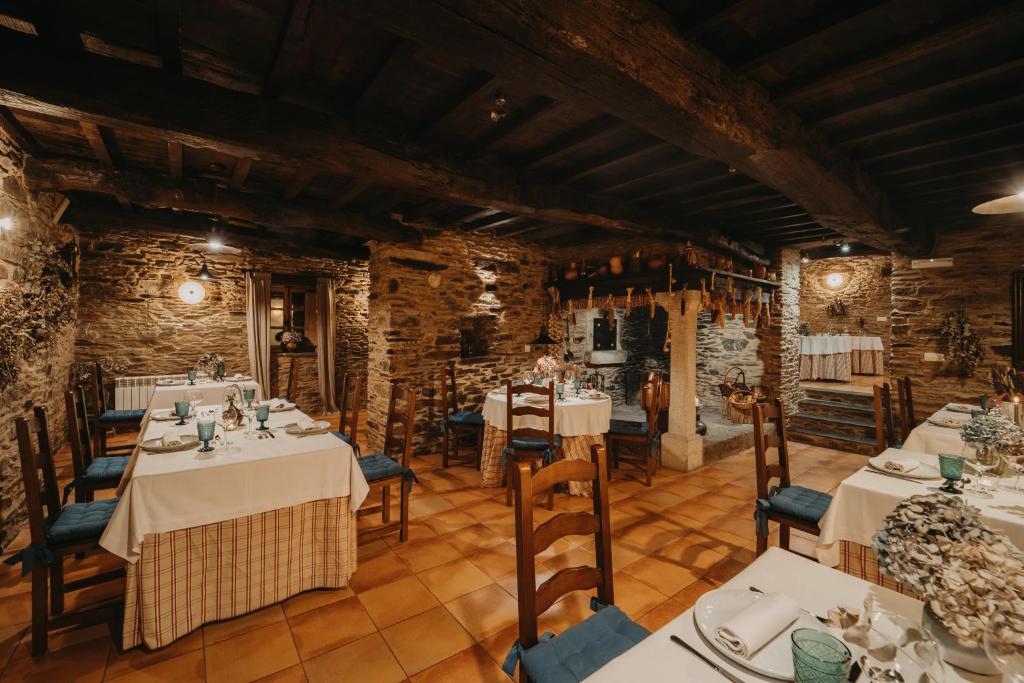 Comedor del restaurante del Pazo Santa María con muros de piedra y vigas de madera