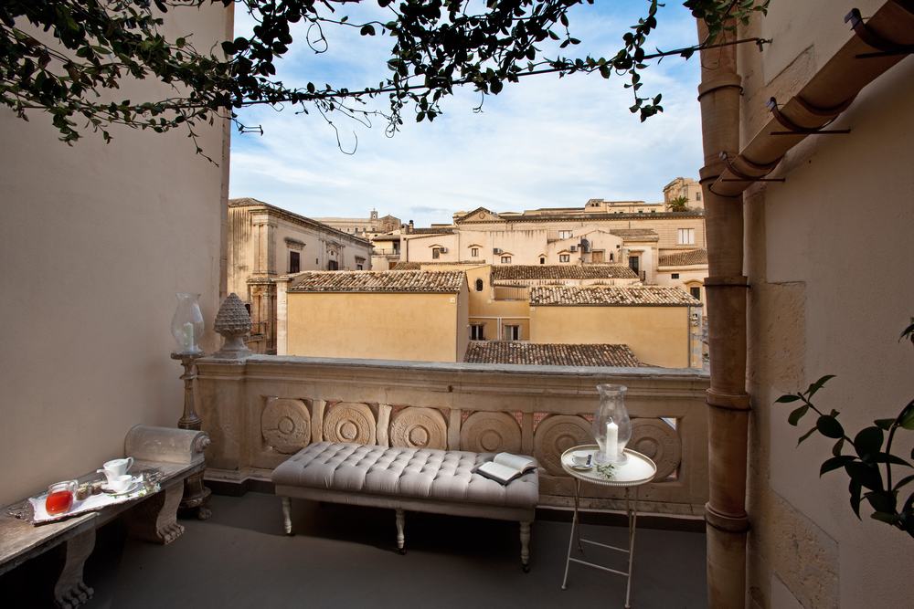 La loggia di Seven Rooms Villadorata affacciata sui tetti barocchi di Noto